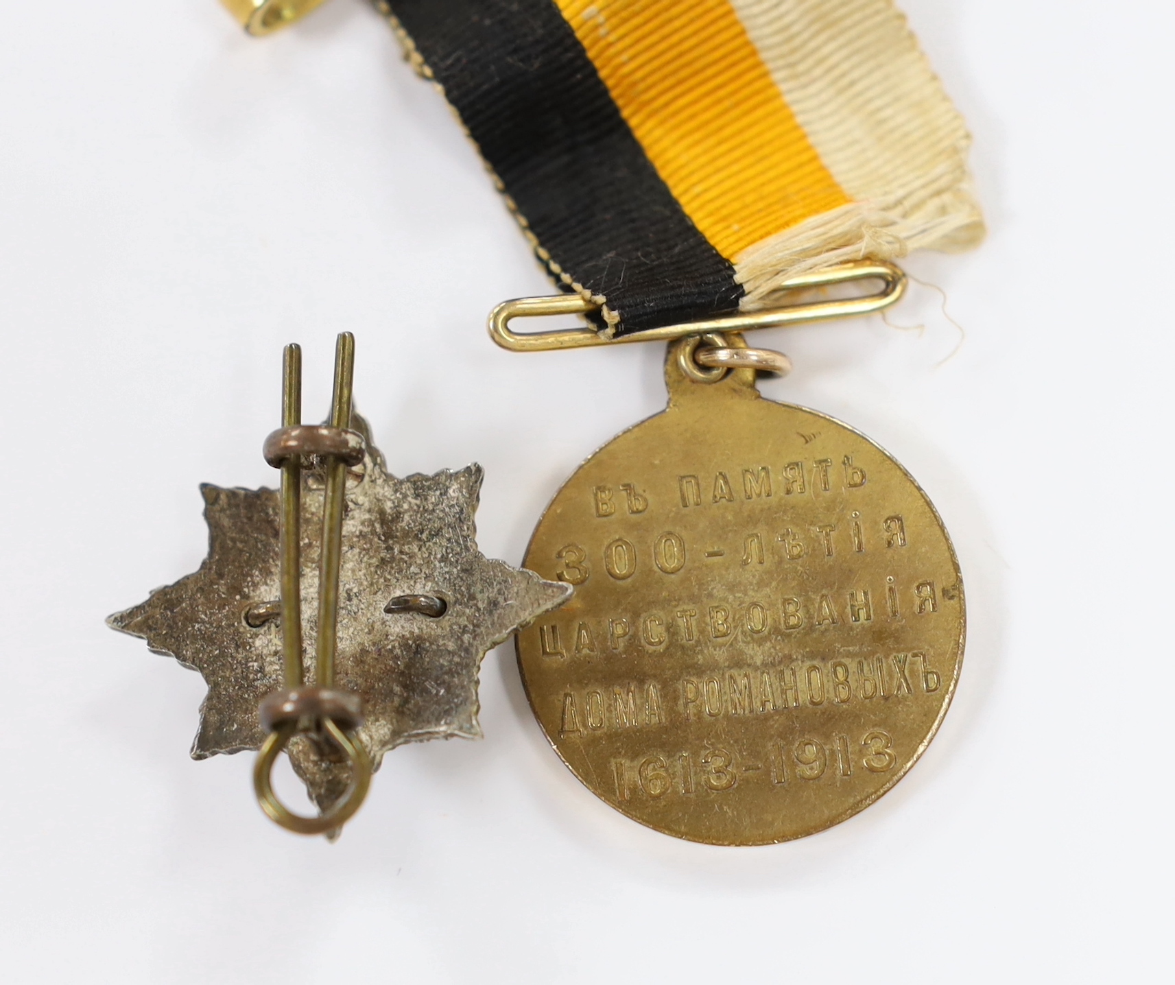 A Russian commemorative House of Romanov medal and a regimental clasp, 1922